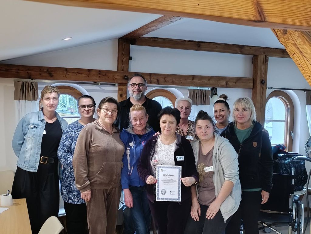 Zdjęcie przedstawia uczestniczki szkolenia pokazane od frontu ustawione w grupie. Z tyłu grupy szkoleniowiec Piotr Frołowicz. 